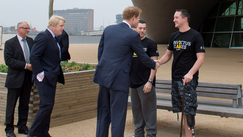 Prince Harry shaking hands with a wounded warrior whilst Boris Johnson is watching